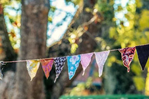 View of colorful handmade triangular party decoration made of fabrics, hung outd 库存照片