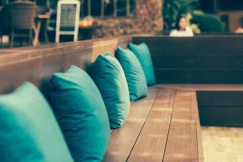 View of comfortable  corner couch with many pillows outside on loft balcony w Stock Photos