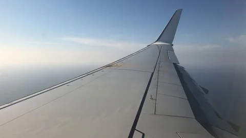 View of commercial plane wing in clouds Stock Footage 98635479