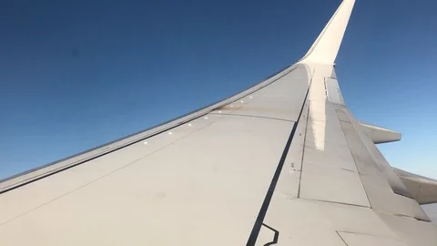 View of commercial plane wing as it turns and banks in flight Stock Footage 98635579