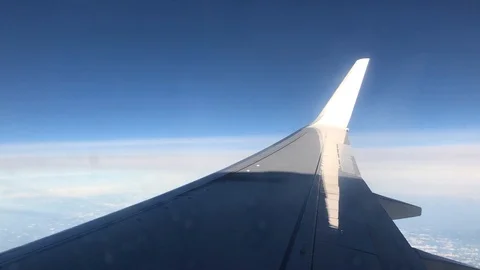 View of commercial plane wing over sea and blue sky horizon Stock Footage 98635521