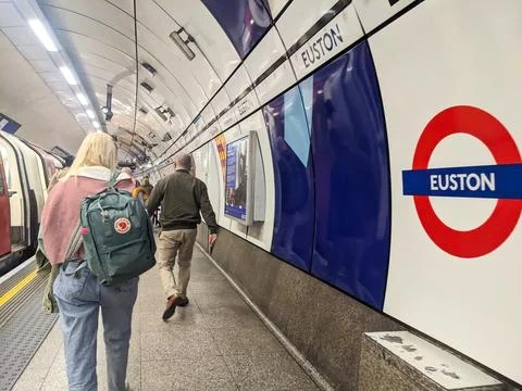 View of commuters walking along the iconic curved platform of Euston Tube Stock Photos
