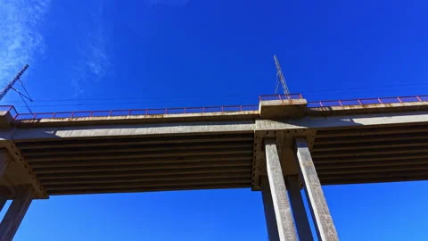 View of a concrete bridge under a clear blue sky with structural columns Stock Footage 331900549