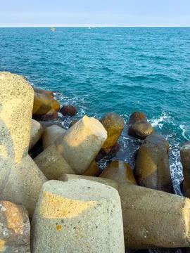 View of concrete structures along the coastline near the ocean on a clear day Stock Photos