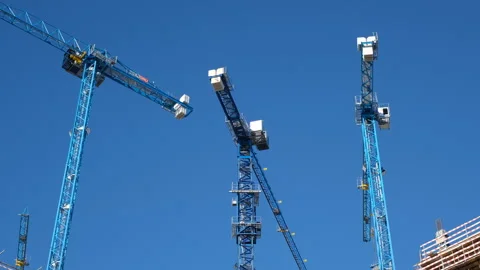 View of construction cranes working against a blue sky. Construction site with Stock Footage 259728756