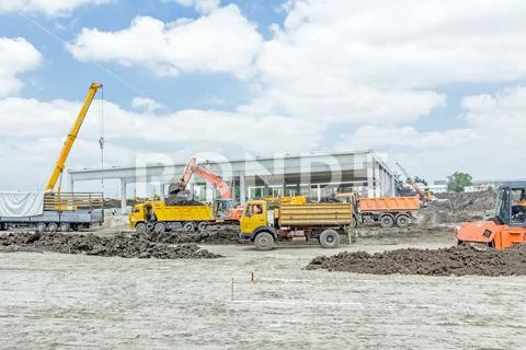 View on construction site with machinery, unfinished modern edifice Stock Photos