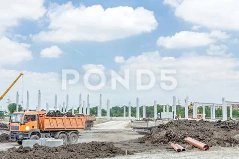 View on construction site with machinery, unfinished modern edifice Stock Photos