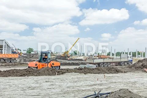 View on construction site with machinery, unfinished modern edifice Stock Photos