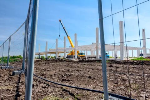 View on the construction site through opened wire fence, restricted area Stock Photos