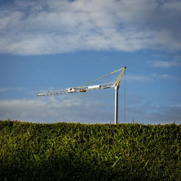 View of a construction tower crane on a cloudy sky Stock Photos
