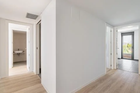 View from the corridor to a compact white room, a terrace with a glass door and 스톡 사진