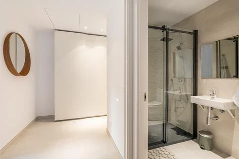 View from the corridor to the corner with wardrobe and mirror and bathroom with Stockfoto's