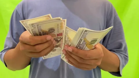 A view of counting dollar bills on a green background. Video stock 326144301