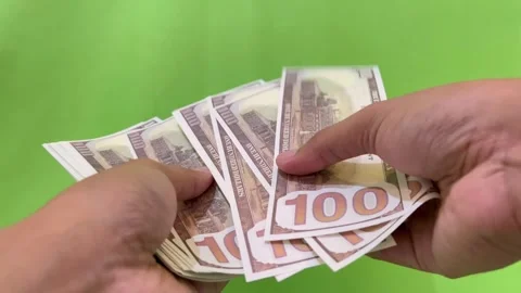 A view of counting dollar bills on a green background. Stock Footage 326144311