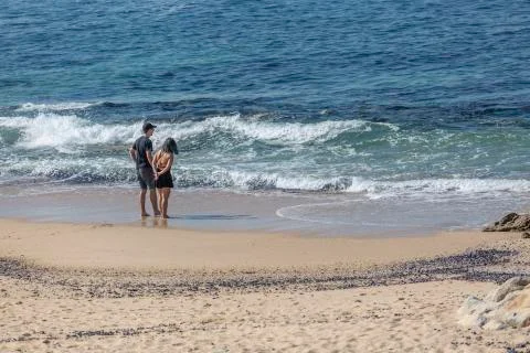 View at a couple, alone on the beach, talking and enjoying on the beach of Le Stock Photos