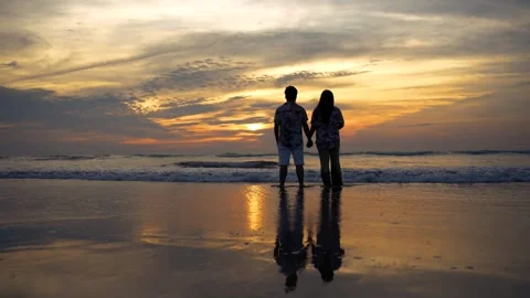 View of a couple holding hands on the beach at sunset, Bangladesh. 스톡 동영상 335022681
