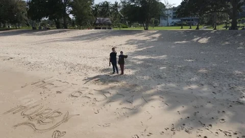 View of Couple standing in front of a beach in Johor Stock Footage 148012574