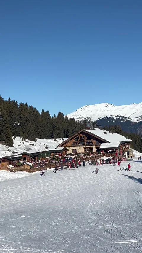 View of Courchevel ski resort with restaurant on the slopes Stock Footage 334408222