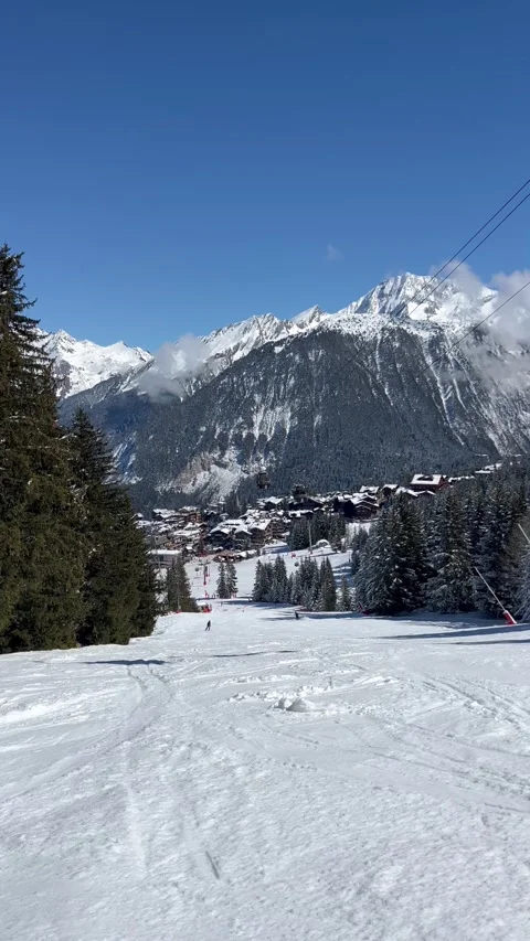 View of Courchevel ski resort slopes and town in the background by winter Stock Footage 337093244