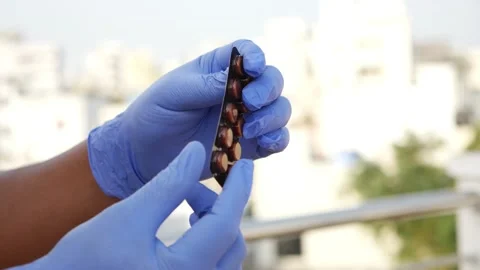 View of covid-19 tablets, Man rotating coronavirus vaccine tablets in hands Video stock 147697090