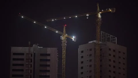 A view of cranes positioned on top of a developing skyscraper in the UAE Stock Footage 334273799