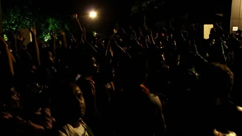 A view of a crowd of devotees dancing at a religious festival late at night Stock Footage 237152138