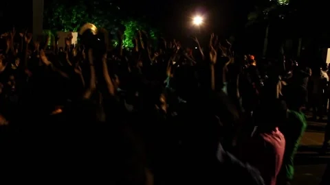 A view of a crowd of devotees dancing at a religious festival late at night Stock Footage 237152140