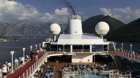 View of cruise ship from top deck as passengers relax by the pool Stockbeeldmateriaal 58444620