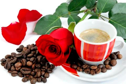 View of a cup of coffee with a red rose and coffee beans on white background. Foto stock