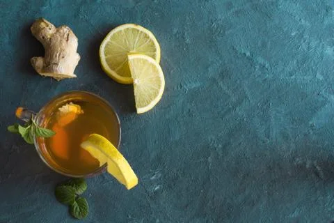 A view of A cup with ginger tea and lemon on a rustic blue table. Stock Photos