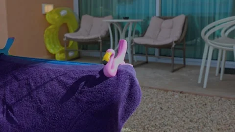 View of cute beach towel clips holding towel on sunbed on hotel room patio. Vidéo 244595352