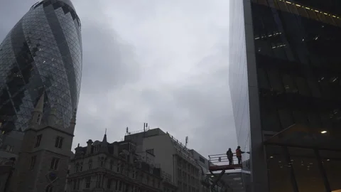 A view of a cylindrical skyscraper and old buildings under overcast skies. Stock Footage 304843416