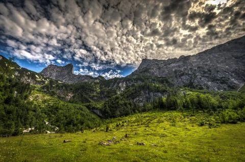 View to Dachstein from Hinterer Gosausee with dramatic blue sky and green forest Stock-Fotos