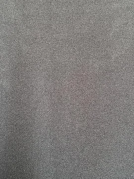 View of a dark grey textured fabric background with a fine woven pattern Stock Photos