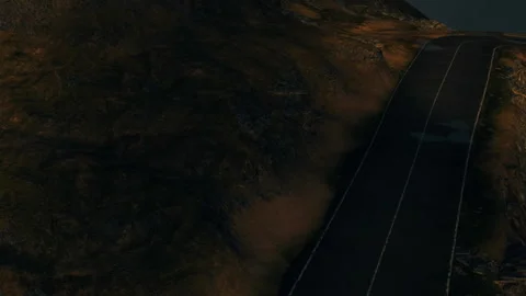 View of a dark road through rough terrain with shadows in the background Stock Footage 340018156