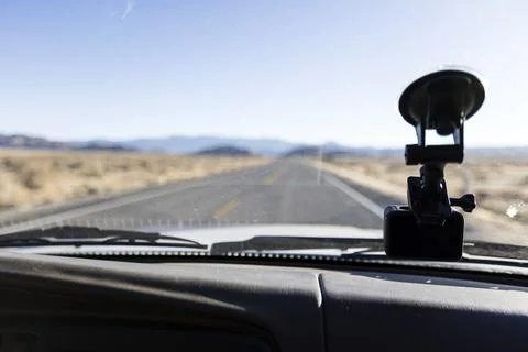 View of the dash next to an action camera with the road ahead defocused Stock Photos