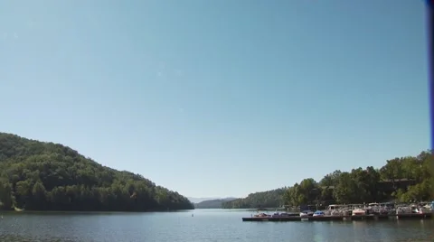 View of deck chairs and boats moored at Lake Lure Stock Footage 54593205