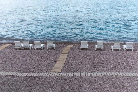 View of deck chairs on the beach and sea Stock Photos