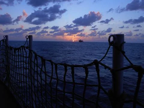 View from the deck of a ship at sea during sunset Stock Photos