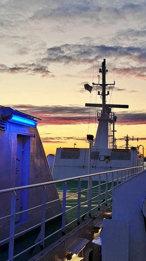 A view from the deck of a ship at sunset, with a radar scanner rotating 스톡 동영상 316387167