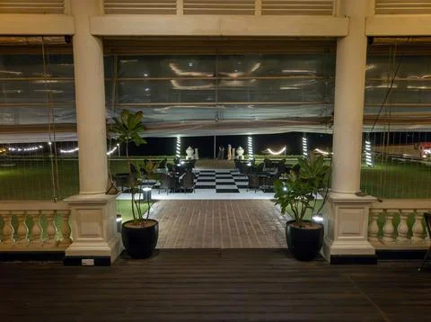 View from deck through stone pillars and balustrade to checker pattern floo.. Stockfoto's