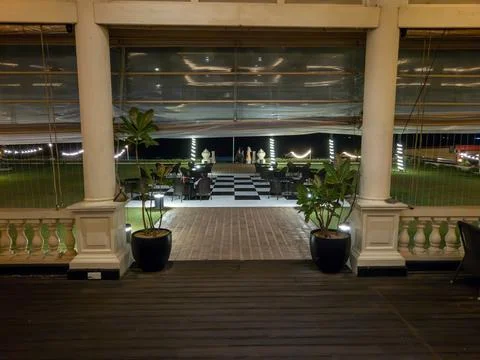 View from deck through stone pillars and balustrade to checker pattern floo.. Stockfoto's