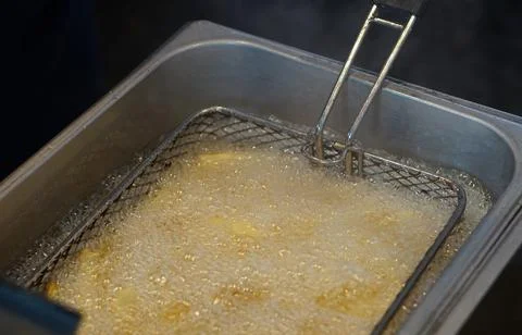 View of deep frying potato chips in elctric machine by Indian street food ven Stock Photos