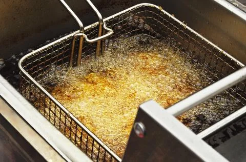 View of deep frying of spring or tornado potato chips,in oil Stock Photos
