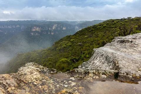 View of deep valley and rolling hills from a rocky cliff edge Stock Photos
