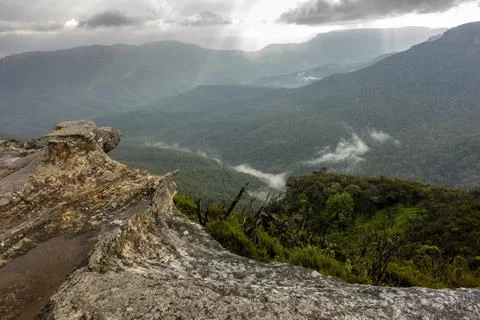 View of deep valley and rolling hills from a rocky cliff edge Stock Photos