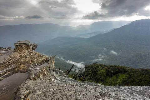 View of deep valley and rolling hills from a rocky cliff edge Stock Photos