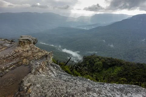 View of deep valley and rolling hills from a rocky cliff edge Stock Photos