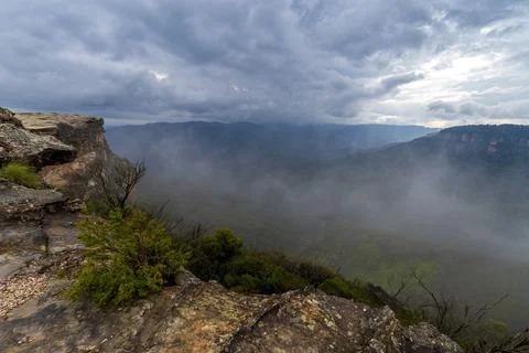 View of deep valley and rolling hills from a rocky cliff edge Stock Photos
