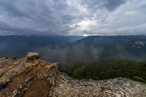 View of deep valley and rolling hills from a rocky cliff edge Stock Photos